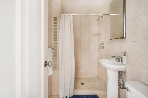 een badkamer met een douchegordijn en een wastafel bij 73-1104 New Studio UWS Doorman Gym in New York
