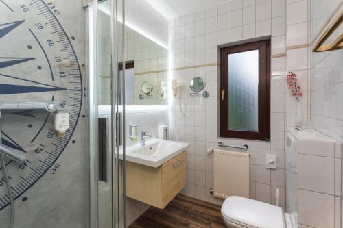 a bathroom with a sink and a toilet at Hotel & Restaurant Hanse Kogge in Koserow