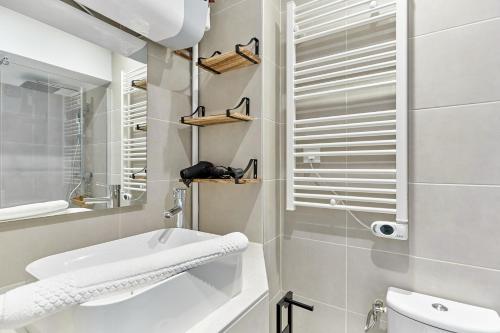 ein Badezimmer mit einem Waschbecken, einem WC und einem Spiegel in der Unterkunft Charming 1 bedroom flat Coeur du Marais By Studio Prestige in Paris