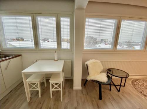 cocina con mesa blanca, sillas y ventanas en Mini-Studio in Center, en Vaasa