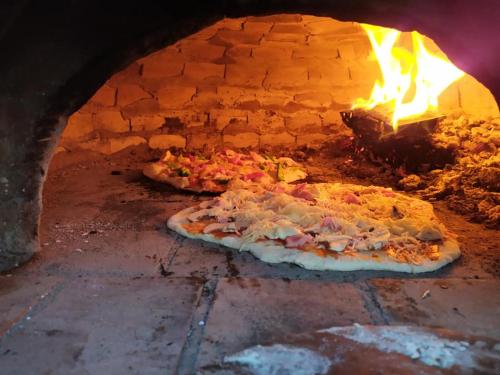 two pizzas are cooking in a brick oven at Gîte Le Charme d'Argent in Charmois-devant-Bruyères