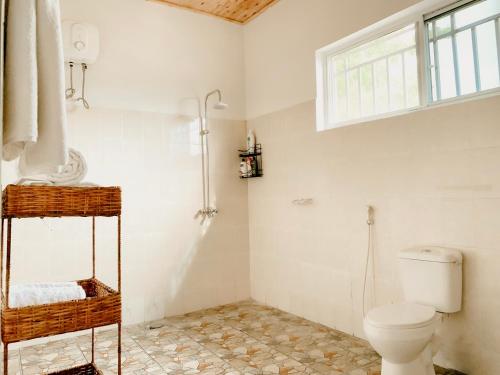 baño con aseo y ventana en Perfect Beach House In Kigamboni en Dar es Salaam