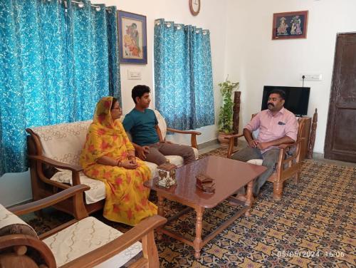 a group of three people sitting in a living room at Rawla in Ābu Road