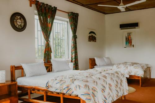 2 camas individuales en una habitación con ventana en Perfect Beach House In Kigamboni en Dar es Salaam