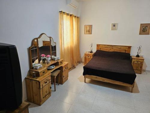 - une chambre avec un lit, un bureau et un miroir dans l'établissement House at Mosta view to Mdina, à Mosta