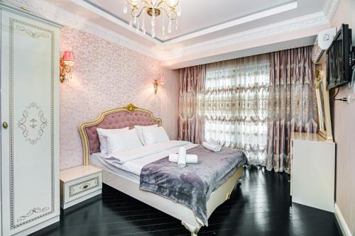 um quarto com uma cama e um lustre em Park Azure Deluxe Apartment By Baku Housing em Baku