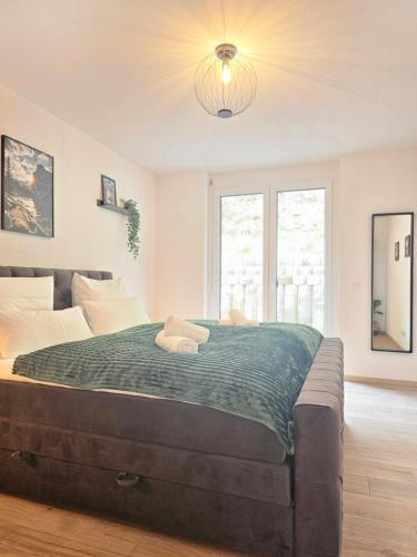 una camera da letto con un grande letto con una coperta verde di Black Forest I Sauna I Boxspring I Nespresso I Wasserfälle I Talblick a Todtnau
