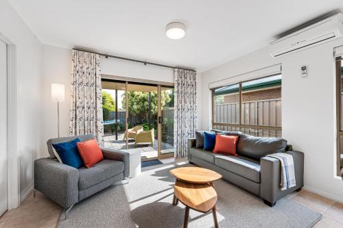 a living room with two couches and a table at Cerca Del Agua family and pet friendly in Encounter Bay