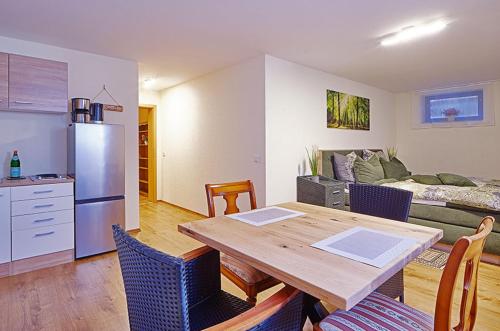 a kitchen and living room with a wooden table in a room at Komfort Appartement Moers-Repelen - Ruhige Lage - Sackgasse in Moers
