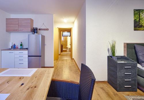 a kitchen with a refrigerator and a table and chairs at Komfort Appartement Moers-Repelen - Ruhige Lage - Sackgasse in Moers