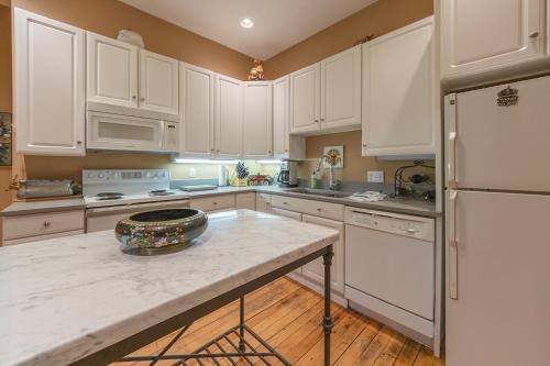 a kitchen with white cabinets and a white refrigerator at Tree House - Downtown Saugatuck - Walk to all the local shops in Saugatuck