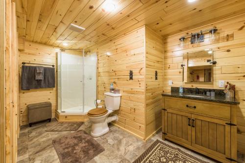 uma casa de banho em madeira com um WC e um chuveiro em Log cabin- Lake- kayaks- close to South Haven em Paw Paw