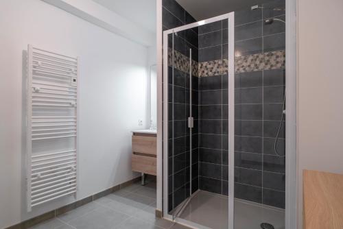 La salle de bains est pourvue d'une douche à l'italienne et d'une porte en verre. dans l'établissement Trévarec au Cabellou - Appartement jardin sur la plage, à Concarneau