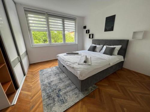 a bedroom with a large bed and a window at Apartment EF in Sarajevo