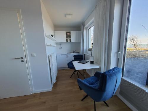 a room with a desk and chairs and a window at Haus Achtern Diek in erster Reihe am Meer in Fehmarn