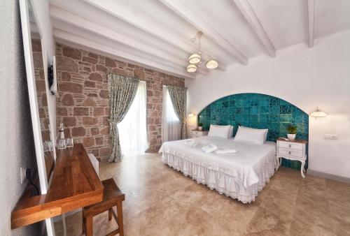 فندق كوندا فورا  في أيفاليك: غرفة نوم بسرير وجدار من الطوب