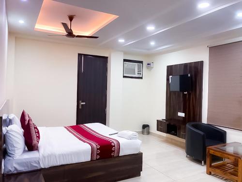 a bedroom with a bed and a desk and a television at Hotel Vandana stay sec-08 in New Delhi