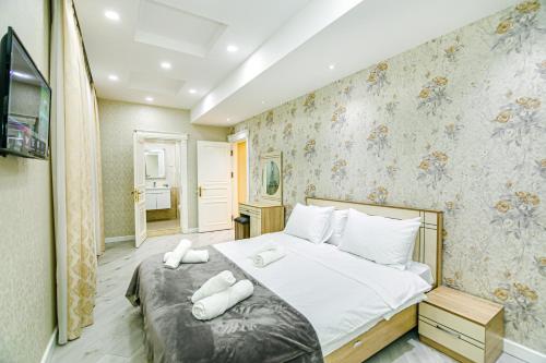 um quarto com uma cama com toalhas brancas em Park Azure Luxury apartment by Baku Housing em Baku