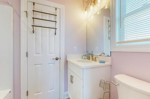 a white bathroom with a sink and a mirror at HB21 Austin Cottage in Holden Beach