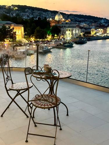 a table and chairs on a balcony with a view of the water at Utopia View in Mytilini