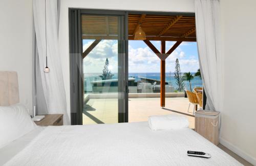 a bedroom with a bed and a view of the ocean at Penthouse de la plage, private lift in Belle Mare