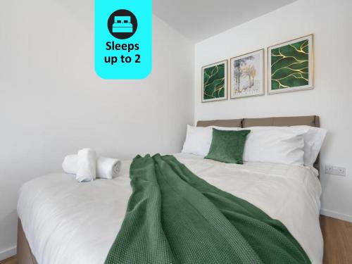 um quarto com uma cama com um cobertor verde em Stylish 1BR Retreat at Station House Milton Keynes em Milton Keynes