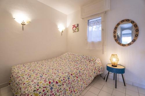 une chambre avec un lit, un miroir et une table dans l'établissement Rdj Terrasse vue mer 100m plage, à Six-Fours-les-Plages