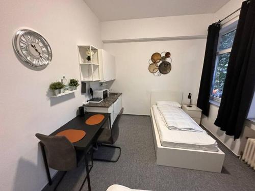 Cette chambre comprend un lit, un bureau et une horloge. dans l'établissement Ferienzimmer in Euskirchen, à Euskirchen