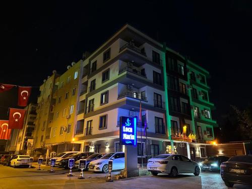 un bâtiment avec des voitures garées devant lui la nuit dans l'établissement Loca Marin, à Mersin