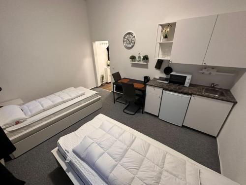 une chambre avec deux lits et une cuisine avec un bureau dans l'établissement Ferienzimmer in Euskirchen, à Euskirchen