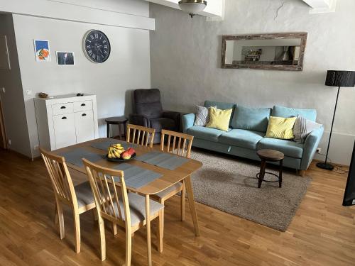 a living room with a table and a blue couch at Kivivete Apartaments in Pärnu