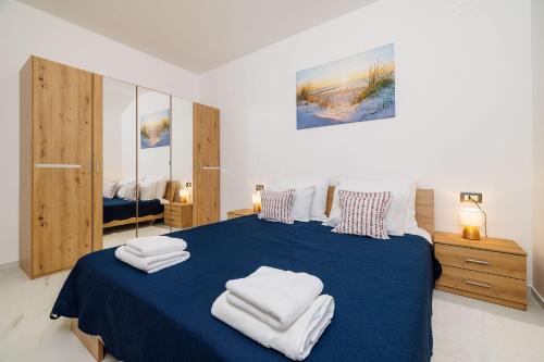 um quarto com uma cama azul com toalhas em Mit Pool, Balkon unweit von Heilschlamm Bucht em Kras