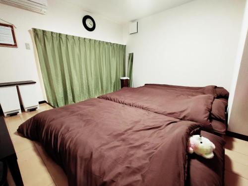 Un dormitorio con una cama con dos ositos de peluche. en SECRET BASE Station Side, en Osaka