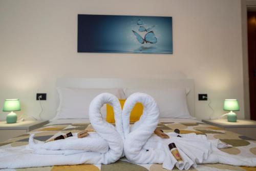 2 cigni fatti di asciugamani su un letto di Appartamento butterfly a Lezzeno
