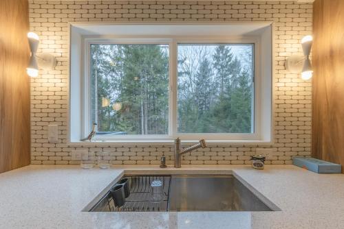 a kitchen sink with a large window above it at Douglas Woods Retreat - Modern Cottage - Newly Remodeled! Walking distance to downtown Douglas! in Douglas