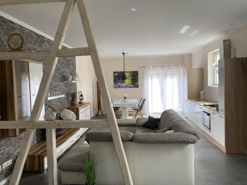 a living room with a couch and a kitchen at Sonnenhof, Ferienwohnung auf Reitanlage in Albstadt