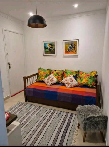 a couch with colorful pillows in a living room at Apartamento na Praia in Praia Grande