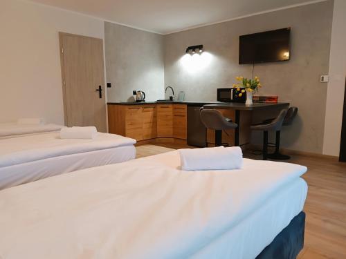 a hotel room with two beds and a desk at Willa Platanowe Wzgórze in Wojcieszyce