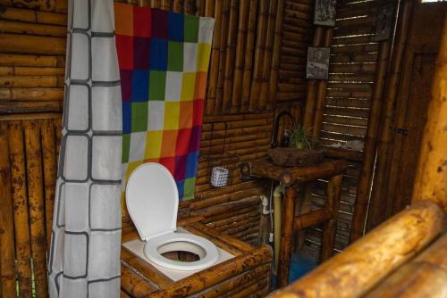 a bathroom with a toilet with a colorful wall at Cabaña Eco amigable en medio de la montaña. in Pastales
