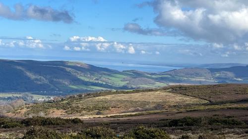 a view of a hill with the ocean in the distance at Exmoor BnB in Withypool on Two Moors Way in Withypool