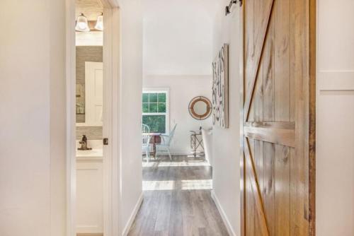 a hallway with a door leading to a dining room at Happy Landings - Farmhouse coastal home with tram and stairs to beach access! in South Haven