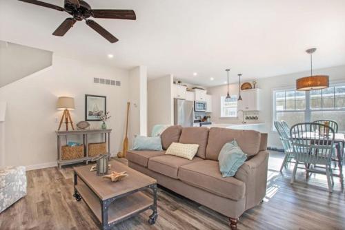 a living room with a couch and a table at Happy Landings - Farmhouse coastal home with tram and stairs to beach access! in South Haven