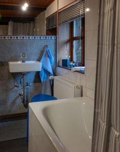 a bathroom with a bath tub and a sink at Ferienwohnungen - Karin Kehne -Gartenblick in Bodenwerder