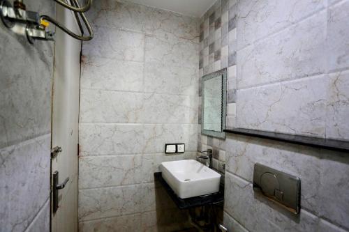 Hotel Shillo Nizamuddin في نيودلهي: حمام مع حوض ومرآة