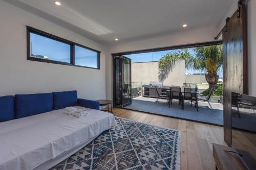 a bedroom with a bed and a balcony with a table at Entire House in Port Melbourne w Parking & Pool in Melbourne