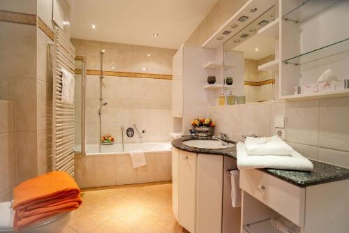 La salle de bains est pourvue d'un lavabo et d'une baignoire. dans l'établissement Ferienwohnungen Tivoli, à Bad Reichenhall