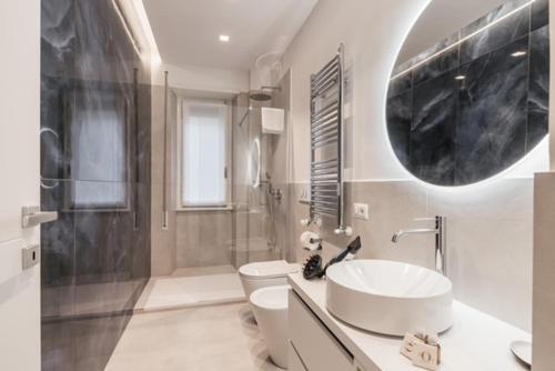 un bagno con lavandino, water e specchio di THE FIFTH Properties a Roma