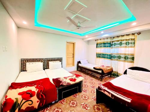 Serene Guest House في سكردو: غرفة نوم بسريرين وسقف ازرق