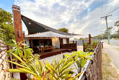 a house with a wooden porch and a fence at Vila Paus Satu - Ocean Views Hervey Bay in Hervey Bay