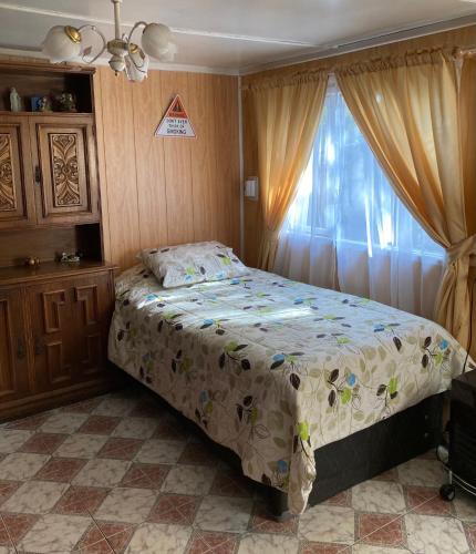 1 dormitorio con cama y ventana en Cabaña independiente, en Coyhaique